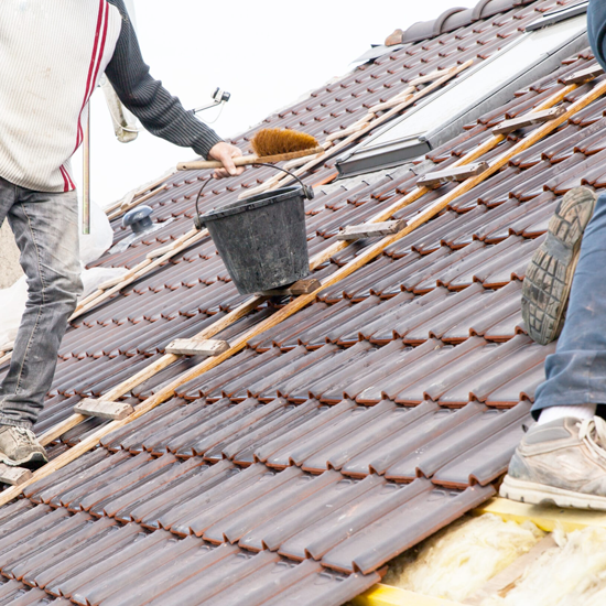 What-Our-Roof-Maintenance-Services-Include- Full shot of a worker performing roof maintenance on a metal roof