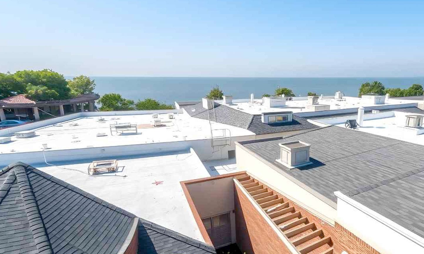 Commercial roofing contractors working on a building rooftop.